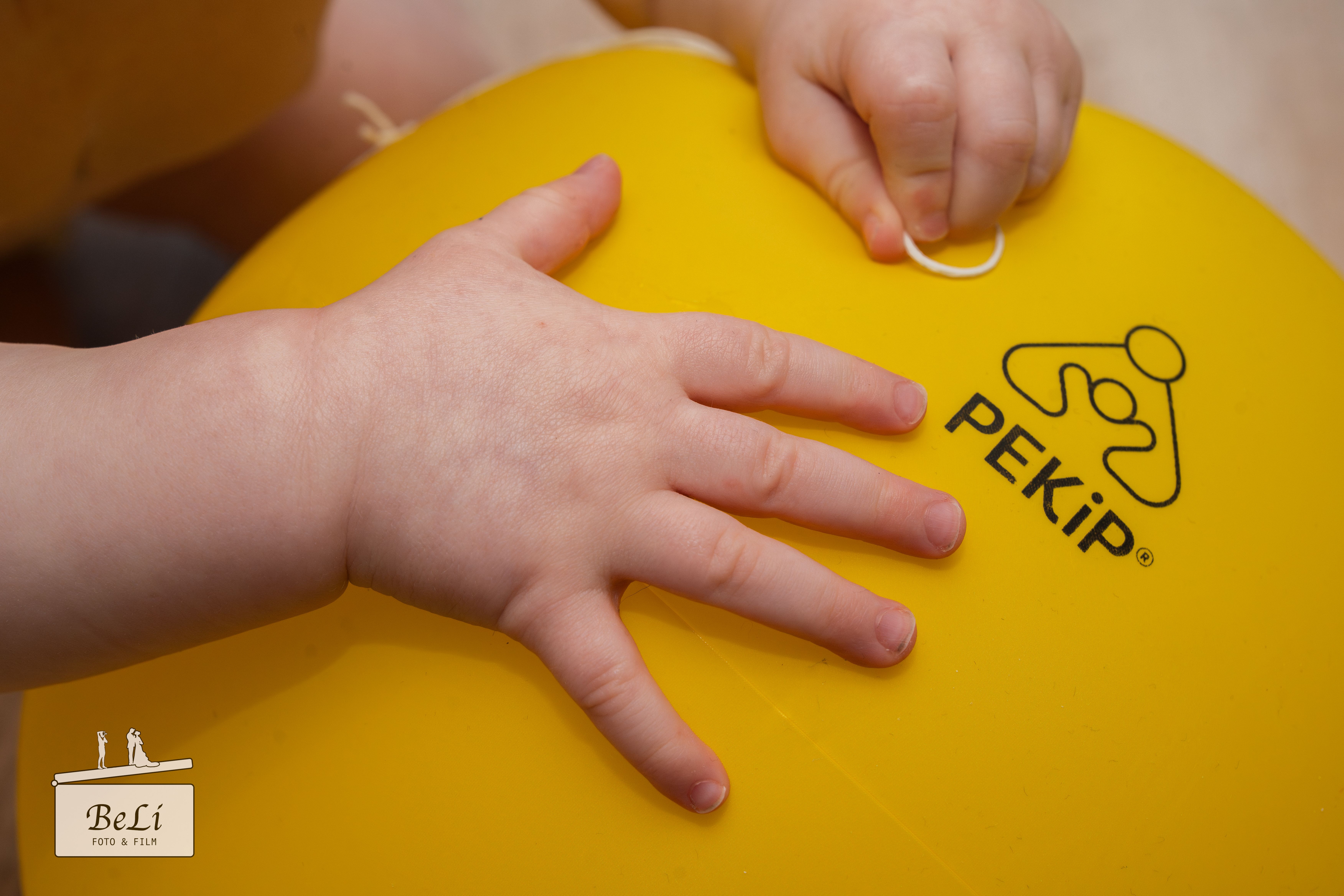 Babyhände auf Wasserball